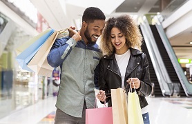 couple in mall looking in shopping bags
