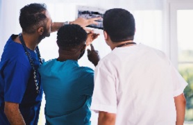 three medical professionals viewing x-ray